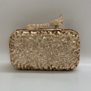 Золотисто-бежевая женская сумочка-футляр, украшенная вышивкой пайетками и застёжкой Павлин